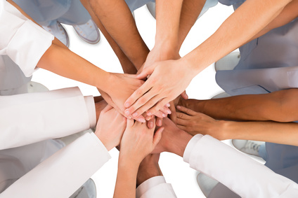 Directly above shot of medical team standing hands against white background