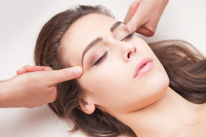 woman acupressure face massage closeup